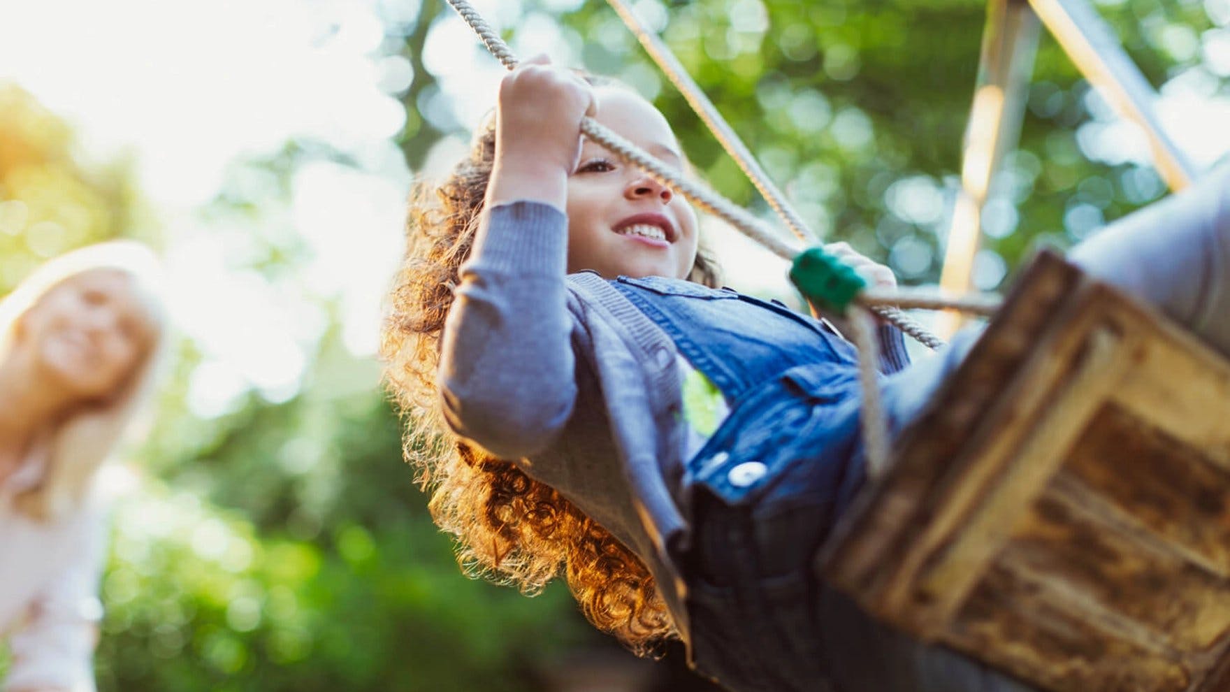 Child outdoors swinging